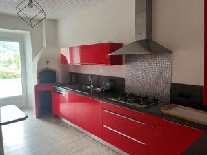 a kitchen with red cabinets and a stove at Sporting Pyrenées House in Vicdessos