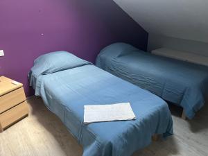 two beds in a room with purple walls at Sporting Pyrenées House in Vicdessos