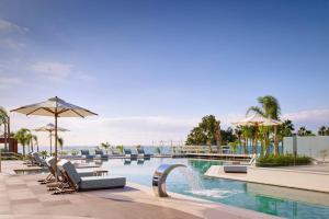 a pool at a resort with chairs and umbrellas at Parklane, a Luxury Collection Resort & Spa, Limassol in Limassol