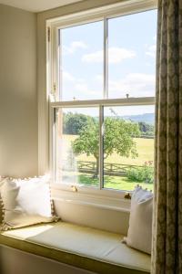 a window seat with a view of a green field at Hollins Farmhouse in Leyburn