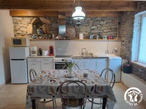 a kitchen with a table and chairs in a room at Rossignol in Le Bez