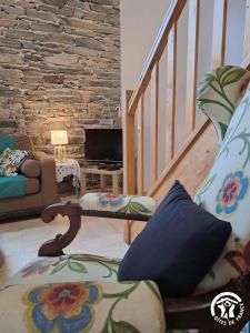 a living room with a staircase with a couch and a tv at Rossignol in Le Bez