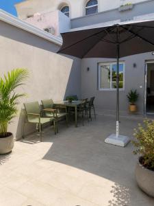 a patio with a table and chairs and an umbrella at Celivine Seaside Residence in Faliraki