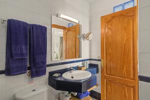 a bathroom with a sink and a mirror and a toilet at Callao Beach 3 in Arrieta +17 photos
