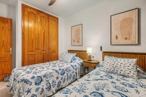 a bedroom with two beds and a wooden cabinet at Callao Beach 3 in Arrieta