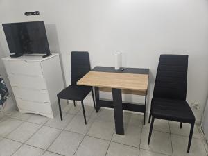 a dining room table with two chairs and a television at Studio Centre Ville in Nice