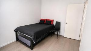 a bedroom with a bed with red pillows and a chair at Casa Amplia con Terraza en Xalapa in Xalapa