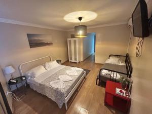 a bedroom with two beds and a television in it at Suites & Apartments - DP Setubal in Setúbal