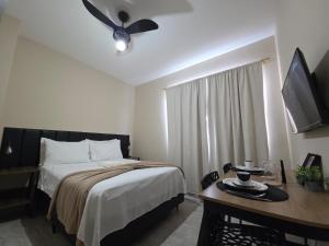 a bedroom with a bed and a ceiling fan at Downtown Rooftop 375 in Imbetiba