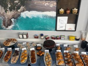 a table filled with different types of donuts and pastries at Hotel Victoria-Bike Friendly vicino Finalborgo e mare in Finale Ligure