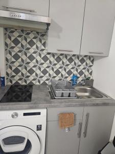 a kitchen with a sink and a washing machine at Studio Centre Ville in Nice +3 photos