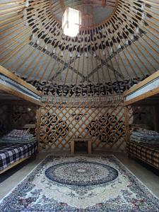 a room with a large wooden ceiling with a rug at 40 Rays Yurts in Bosteri