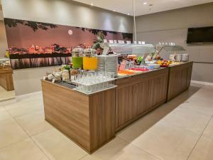 a buffet line with drinks and food on it at Blue Tree Towers Millenium Porto Alegre in Porto Alegre