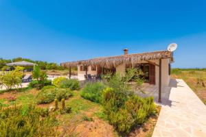 a house with a thatched roof and a garden at Son Fred in Felanitx