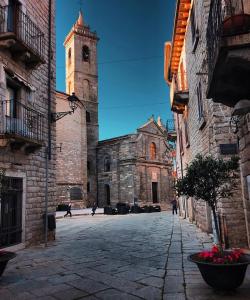 an old stone building with a tower and a church at Al Vecchio Corso B&B in Tempio Pausania