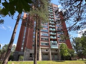 a tall red building with trees in front of it at ViSky Ap in Visaginas