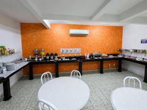 a kitchen with two tables and chairs in a room at Alfa Hotel Nova Mutum in Nova Mutum