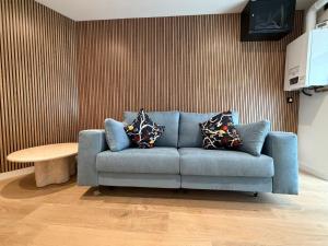 a blue couch in a living room with a table at MTM Rooms in Santander