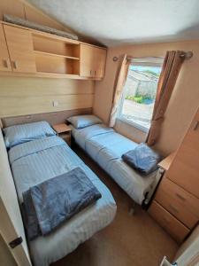a small room with two beds and a window at Winnie the Mobile Home in Galway