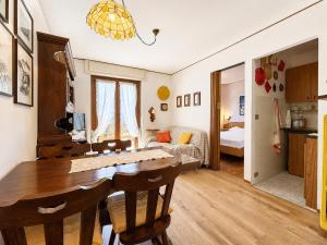 a kitchen and living room with a wooden table and chairs at Hostdomus - Villaggio Alpino in Sauze d'Oulx +6 photos