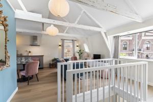a living room with a staircase and a dining room at Abcoude city center in Abcoude