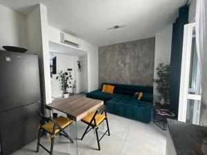 a living room with a blue couch and a table at Glycine House in Varese