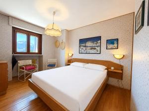 a bedroom with a large white bed in a room at Hostdomus - Villaggio Alpino in Sauze d'Oulx