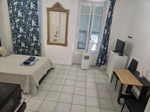 a living room with a bed and a television at Studio Centre Ville in Nice