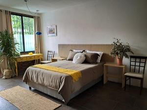 a bedroom with a bed with a yellow blanket on it at Casa Puerto Siete8 in Mexico City