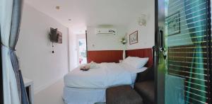 a bedroom with a bed with a teddy bear on it at รักเขาแอนด์บ้านมุง in Ban Mung