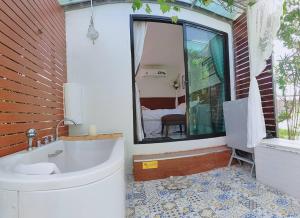 a bathroom with a tub and a sink and a window at รักเขาแอนด์บ้านมุง in Ban Mung