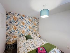 a bedroom with a bed with a floral wall at Le Nevoy in Nevoy