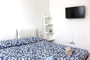 a bedroom with a bed and a tv on a wall at Glycine House in Varese