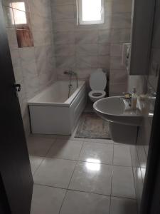 a bathroom with a tub and a toilet and a sink at Apartament Militari in Chiajna
