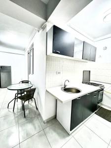 a kitchen with a sink and a table at Apartament Militari in Chiajna