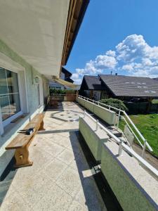 a patio with a wooden bench on a house at Apartma Regrat in Lesce