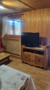 a living room with a tv on a wooden table at Le montagnard in Lullin