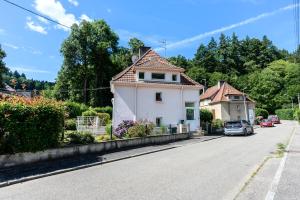 a small white house on the side of a road at Maison La Mirabelle in Thann
