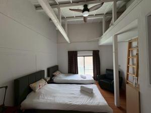 a bedroom with two beds and a ceiling fan at Runbull House in Tokyo