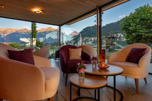 a room with chairs and a table with a view of mountains at Salzano Basic Rooms Interlaken in Interlaken