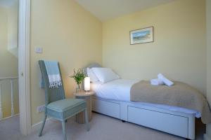 a small bedroom with a bed and a chair at 1 Abiff Place in Sidmouth