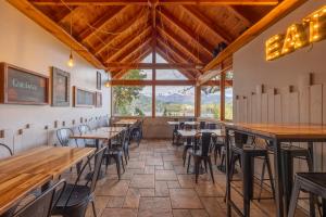 ein Esszimmer mit Tischen und Stühlen und einem großen Fenster in der Unterkunft Peninsula Petit in San Carlos de Bariloche