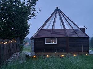 a small cabin in a field with a roof at Lavvo med glasstak in Svenseid +15 photos