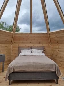 a bed in a room with a large window at Lavvo med glasstak in Svenseid
