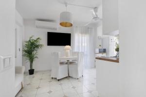 a white living room with a white table and chairs at A due passi dal mare in Oliveri