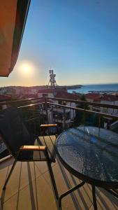 a table and chairs on a balcony with a view of the ocean at D House in Chernomorets