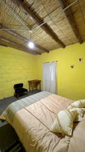 a bedroom with a large bed and a chair at Casa Manuel in Tinogasta