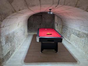 a tunnel with a red pool table in a tunnel at La Tranquillité proche Beauval et Châteaux de la Loire in Loches