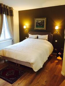 a bedroom with a large bed with white sheets at Villa Kleber in Strasbourg