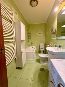 a bathroom with two toilets and a tub and a sink at Stejarului Apartment in Floreşti +13 photos
